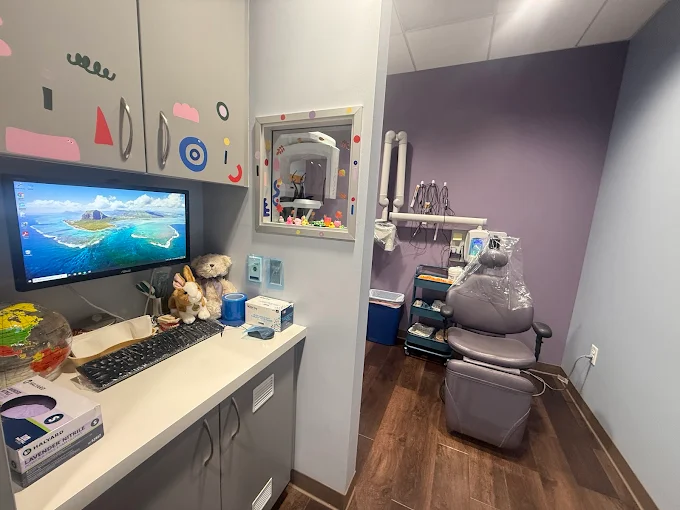 Exam room image with stuffed animals and cute stickers across the cabinets