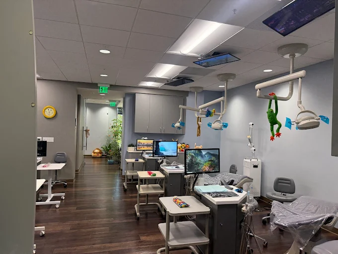 large exam room with three stations. tv's on the ceiling and little stuffed plushies throughout the room
