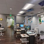 large exam room with three stations. tv's on the ceiling and little stuffed plushies throughout the room